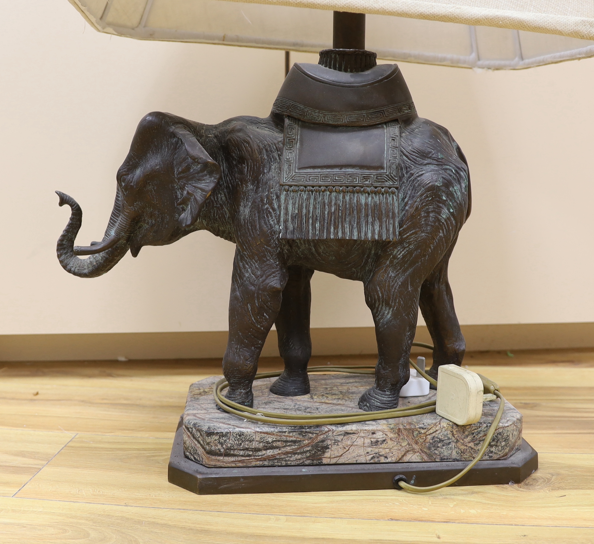 A bronzed elephant table lamp raised on shaped base, with shade, 79cm high